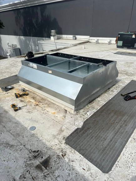 A metal box is sitting on the roof of a building.