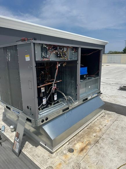A large air conditioner is sitting on top of a roof.