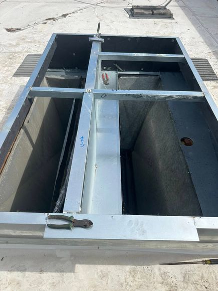 A large metal box with a metal frame is sitting on the ground.