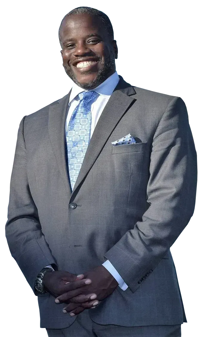 Man in grey suit smiles, arms crossed, blue tie, pocket square.