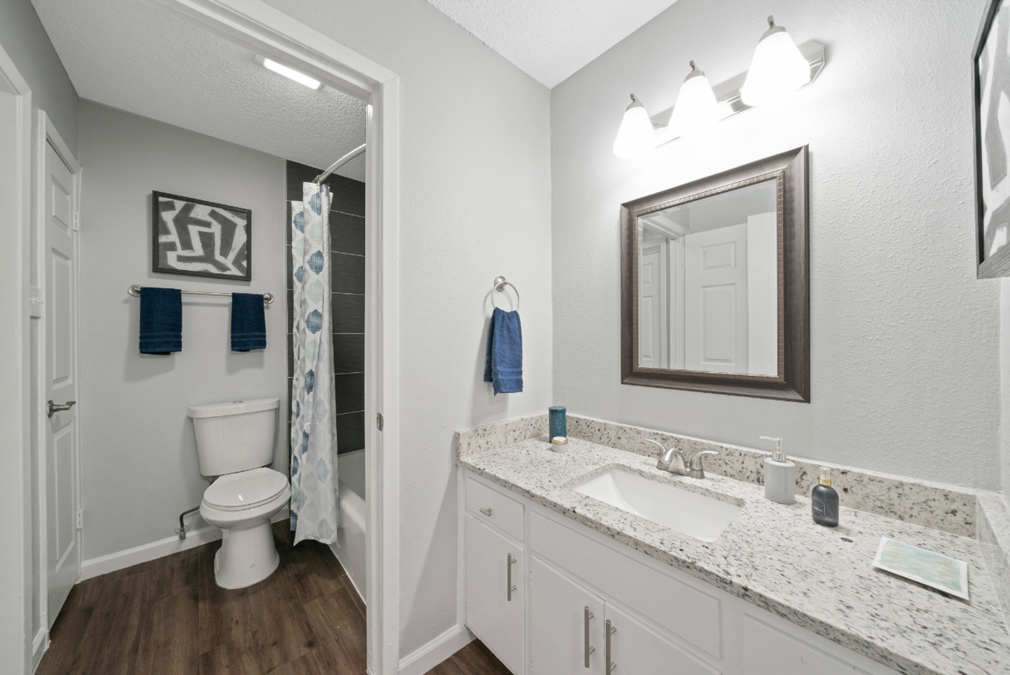 A bathroom with a toilet , sink and mirror.