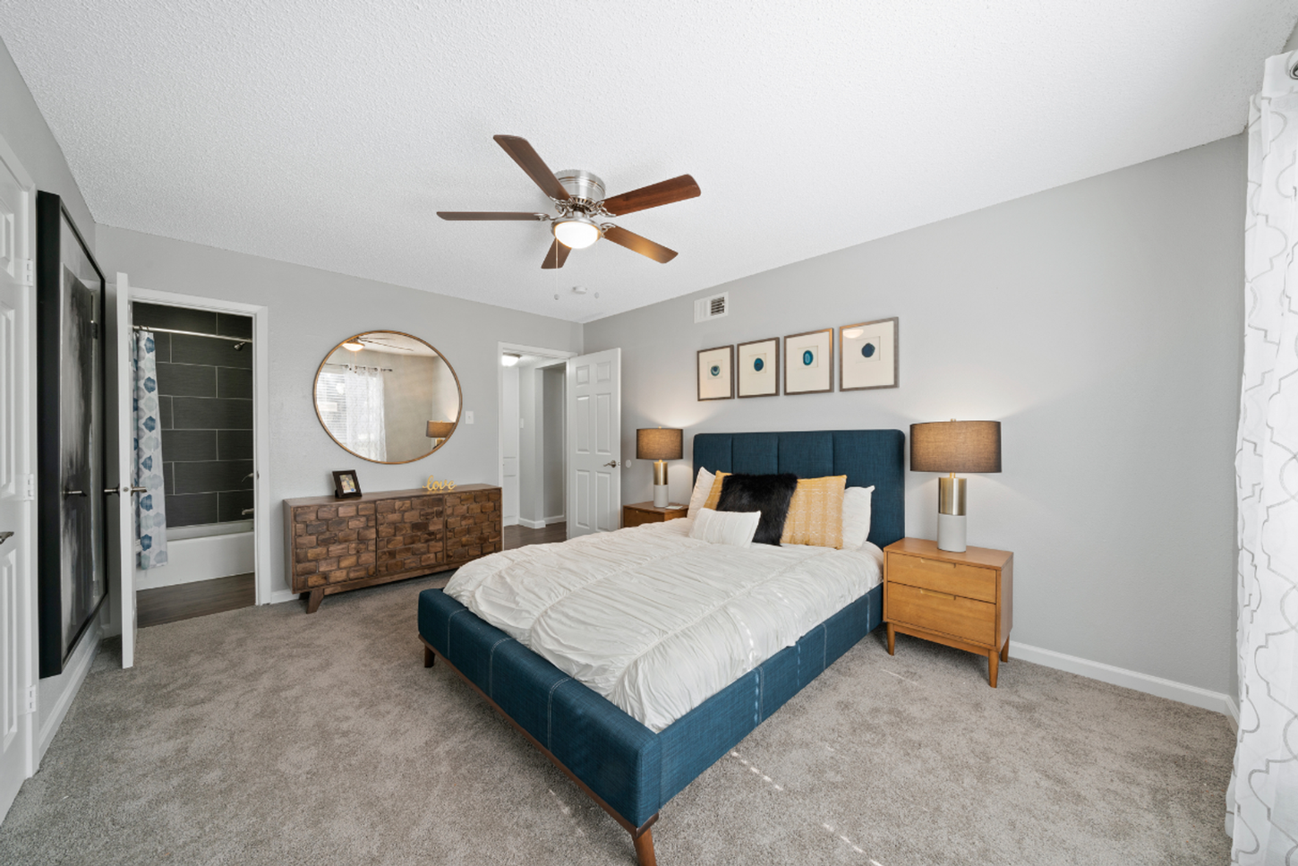 A bedroom with a bed , dresser , nightstand and ceiling fan.