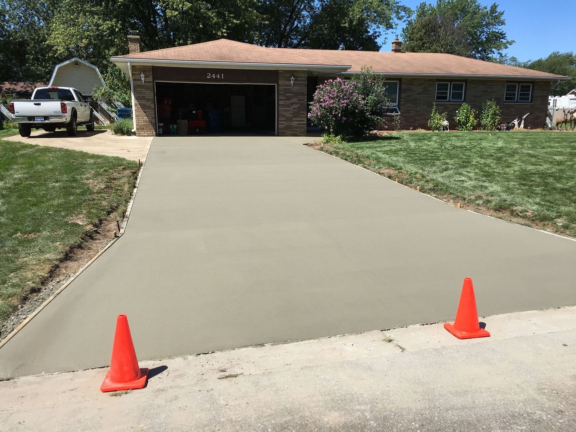 A concrete driveway is being built in front of a house.