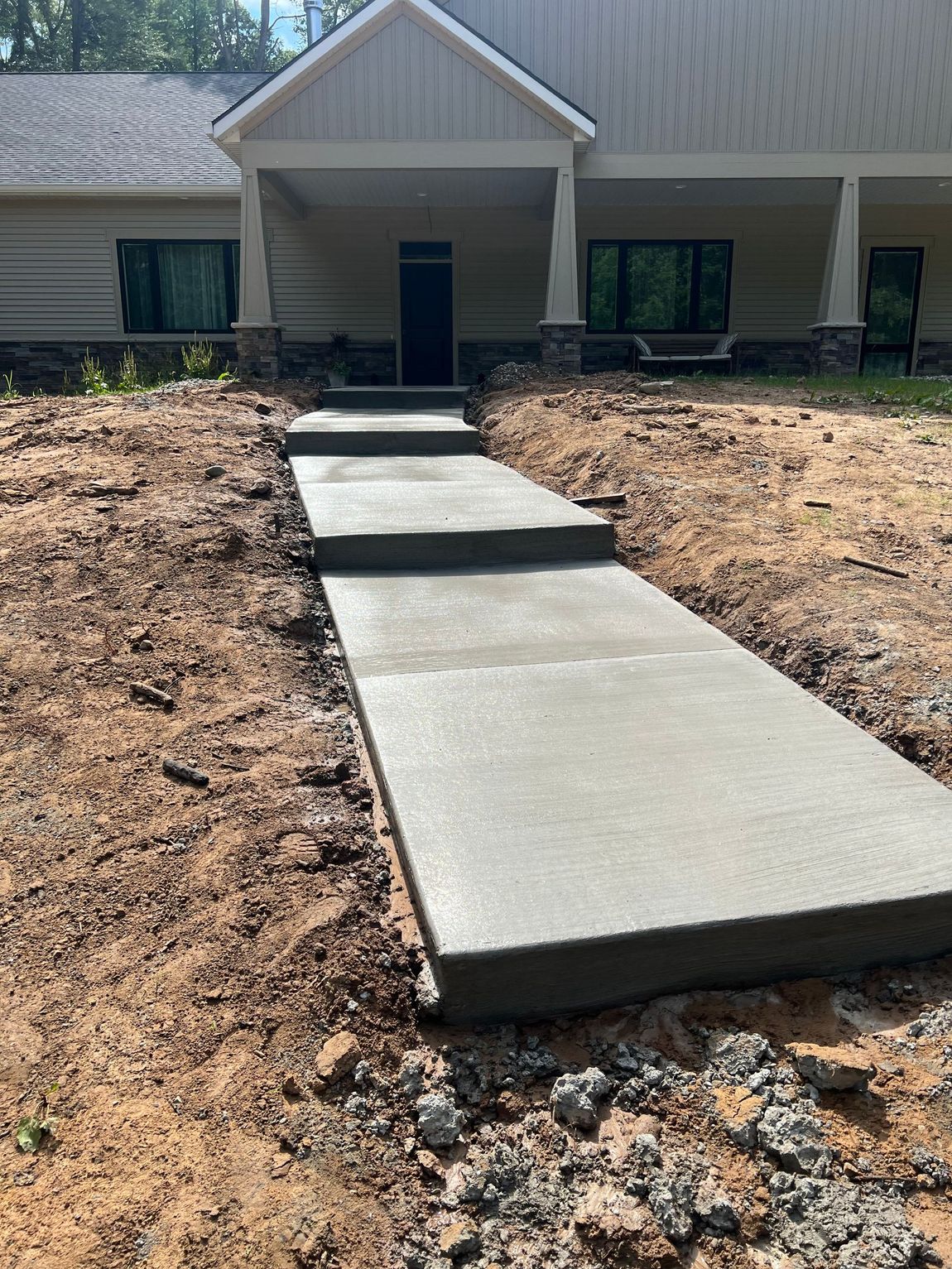 A concrete walkway is being built in front of a house.