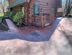 A log cabin with a concrete walkway leading to it