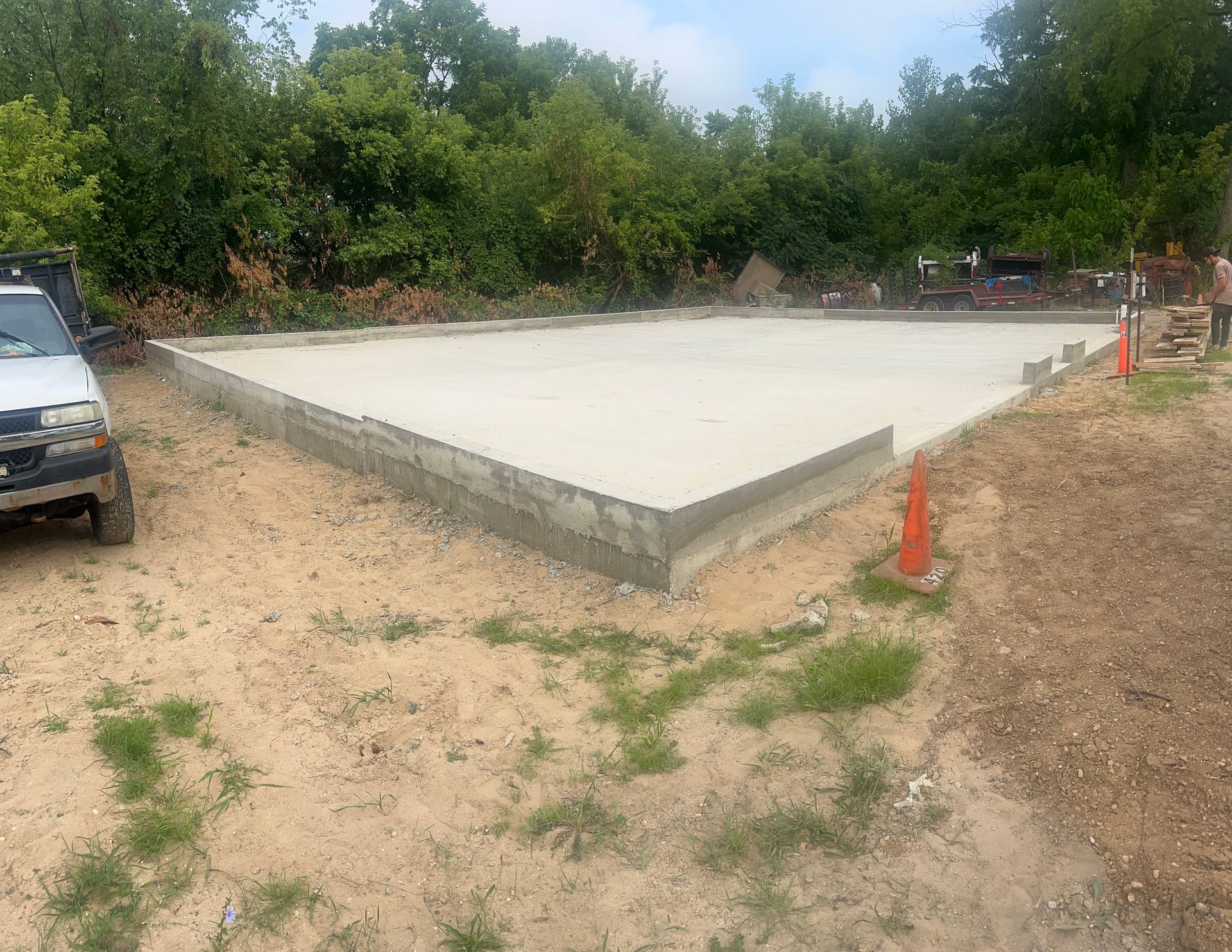 Concrete foundation with cinder block perimeter, set outdoors.