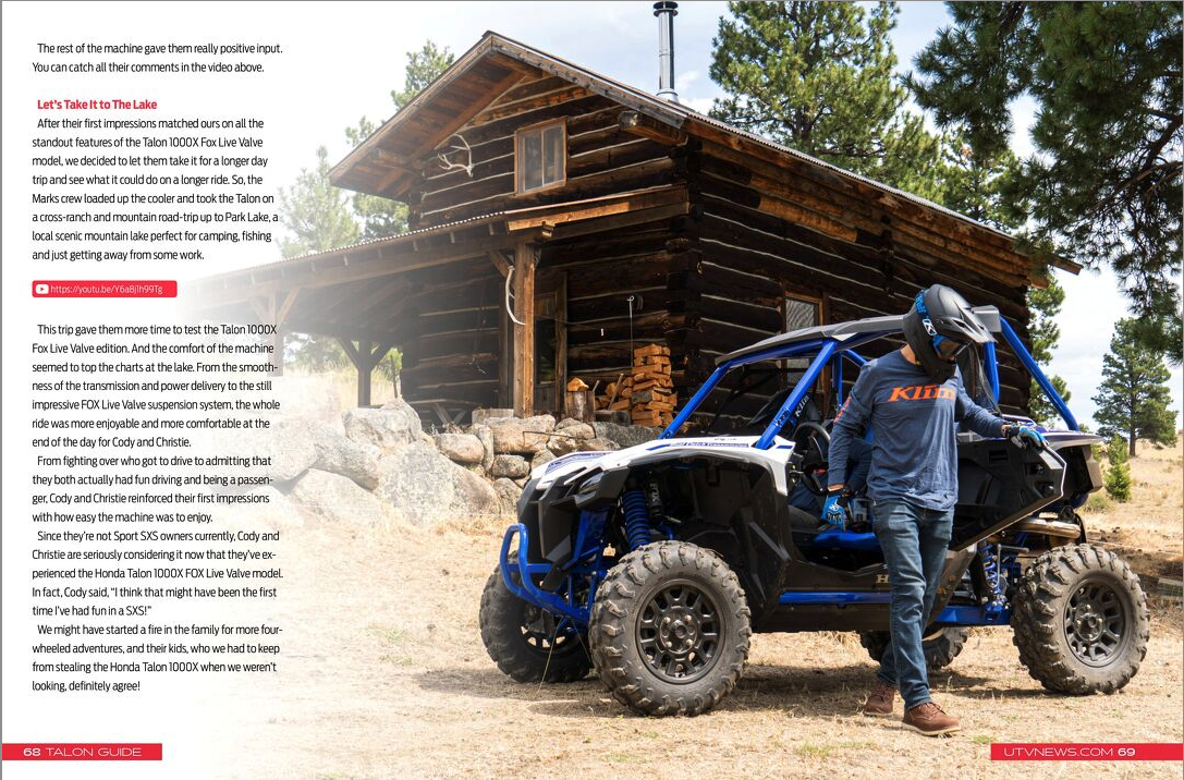 a man is standing next to a atv in front of a log cabin .