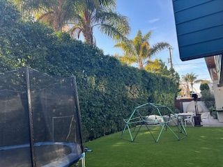 There is a trampoline in the backyard of a house.