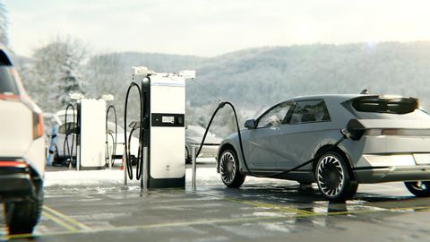 A blue electric car is being charged in a garage.