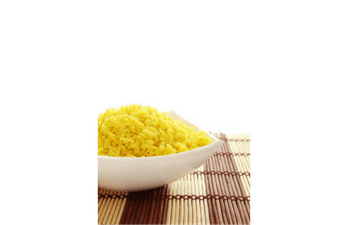 A bowl of yellow rice sits on a bamboo mat