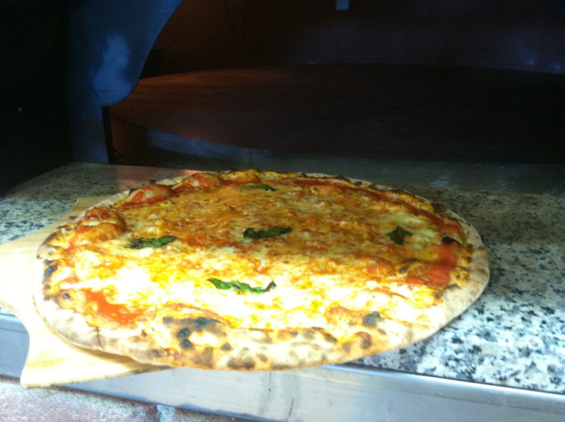 A pizza is sitting on a marble counter top
