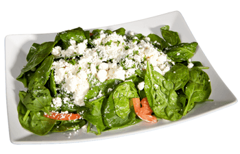 A white plate topped with spinach and feta cheese