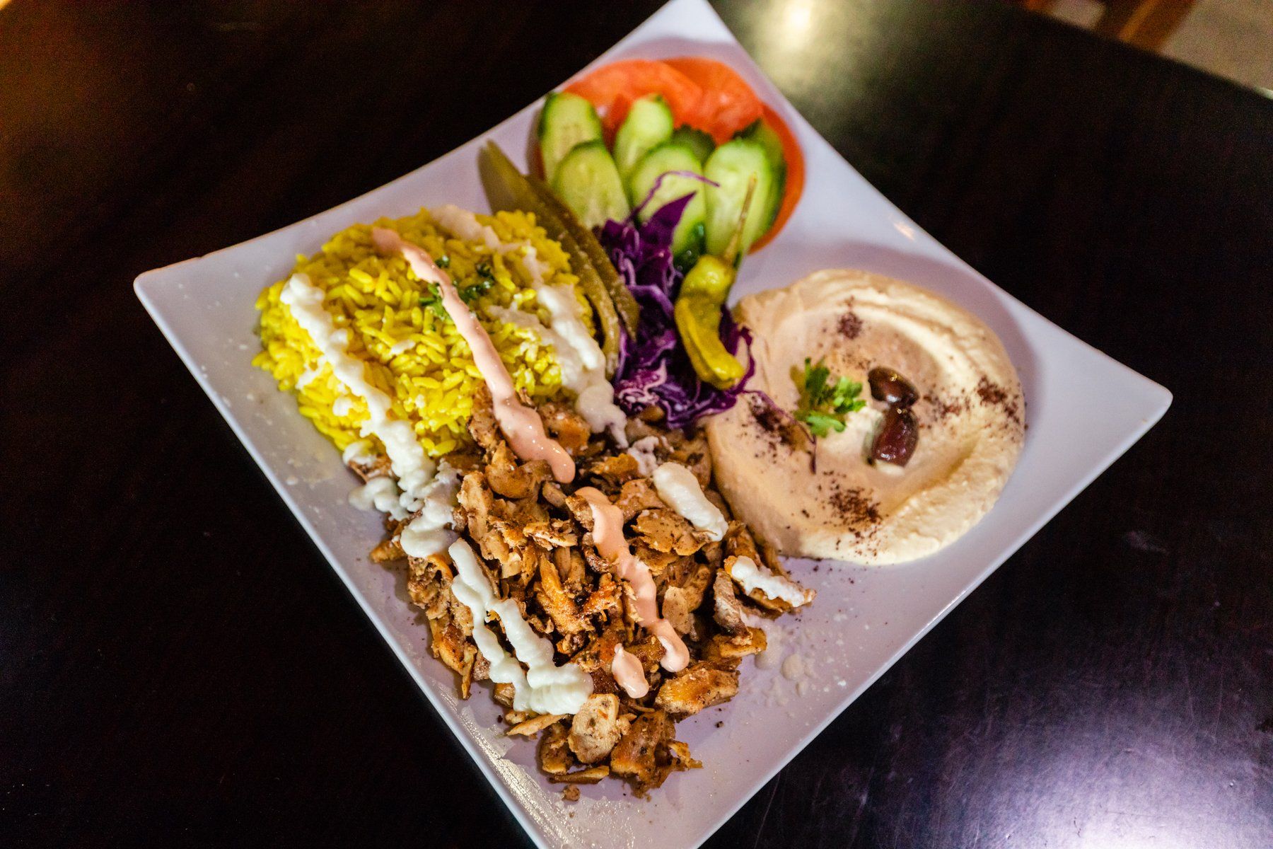 A plate of food with hummus and rice on a table