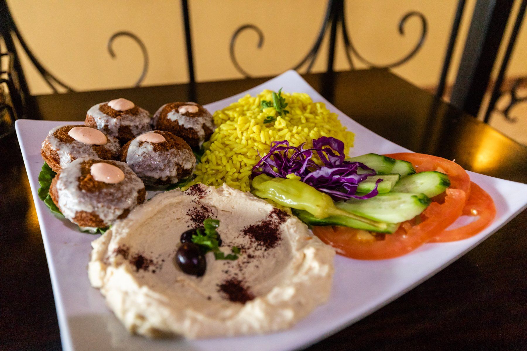 A plate of food with hummus rice and vegetables on a table