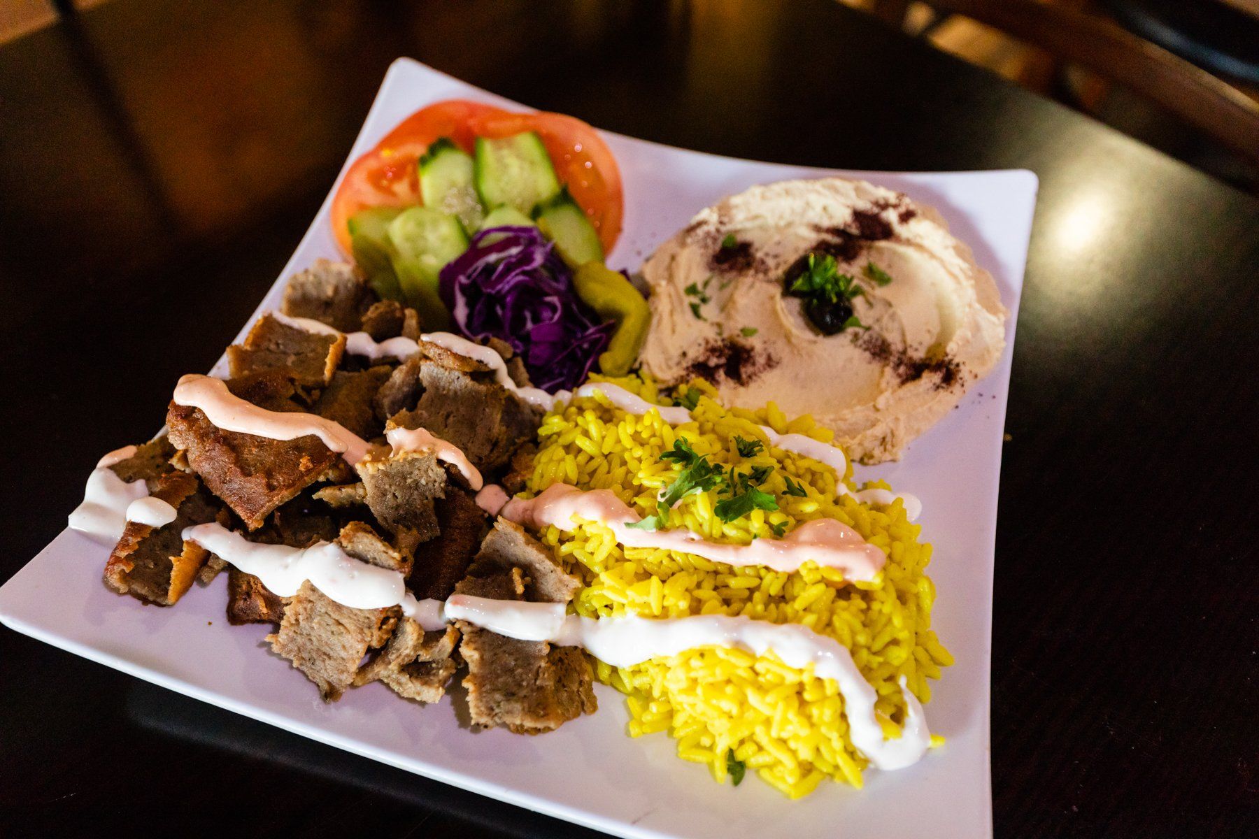 A plate of food with rice and hummus on a table