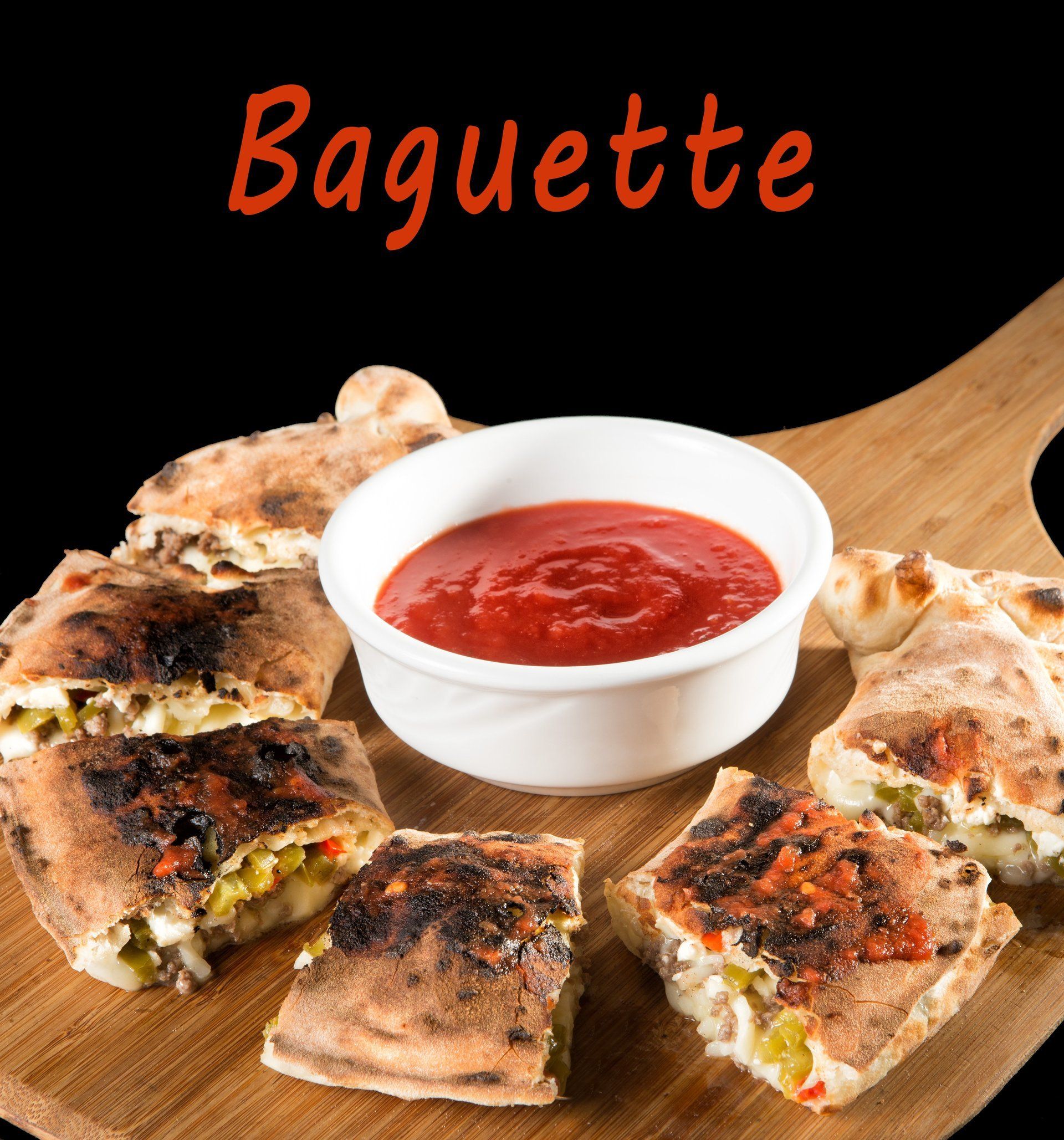 A wooden cutting board with baguette sandwiches and a bowl of ketchup