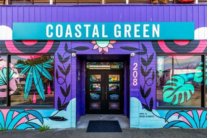 The front of a building with a sign that says coastal green.