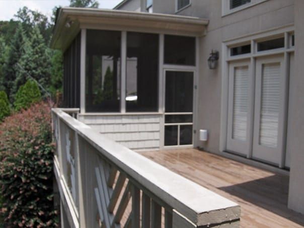 A screened in porch on the side of a house