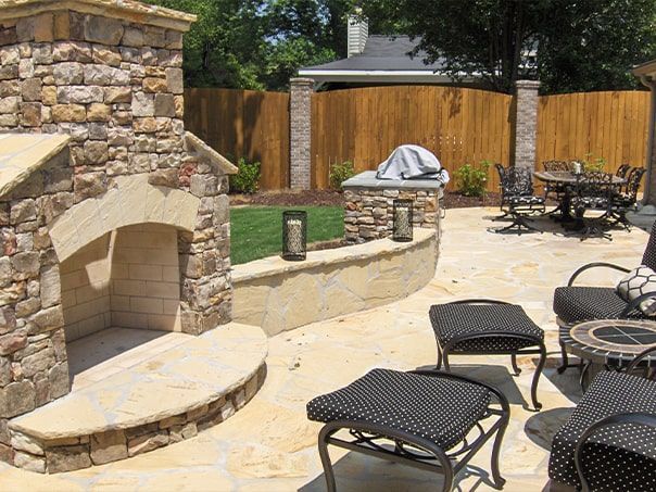 A stone fireplace sits in the middle of a patio