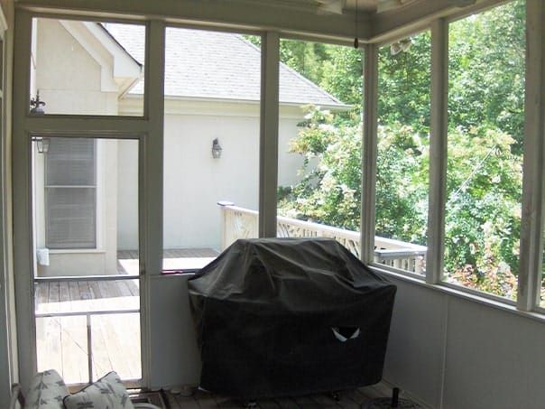 A screened in porch with a grill in it