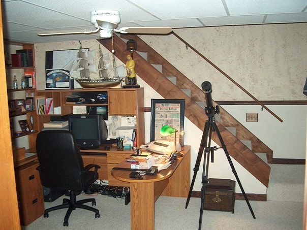 A room with stairs and a desk with a computer on it