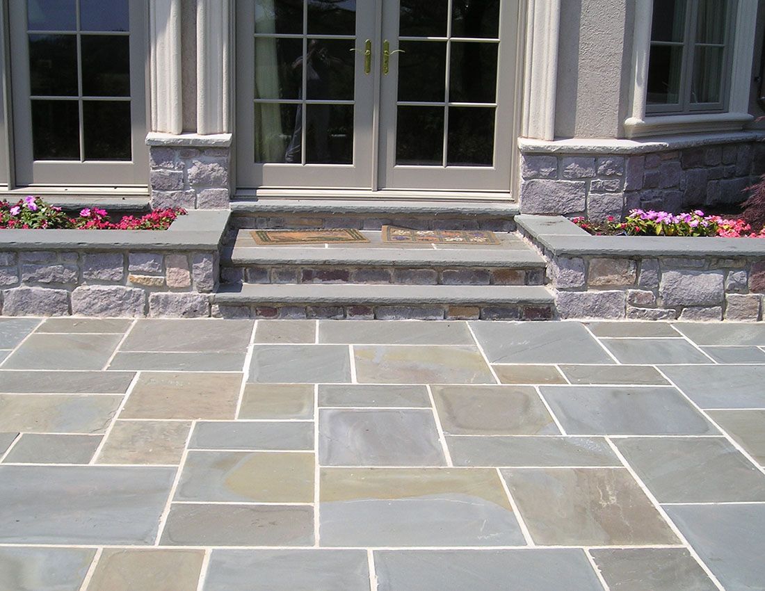 A stone patio with steps leading up to a door