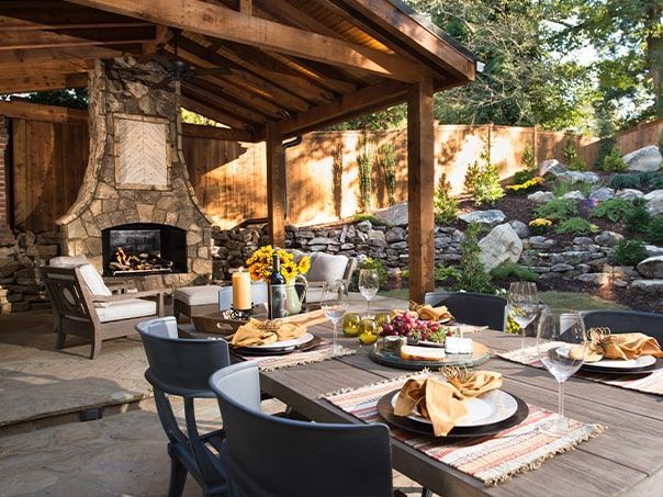 A patio with a table and chairs and a fireplace