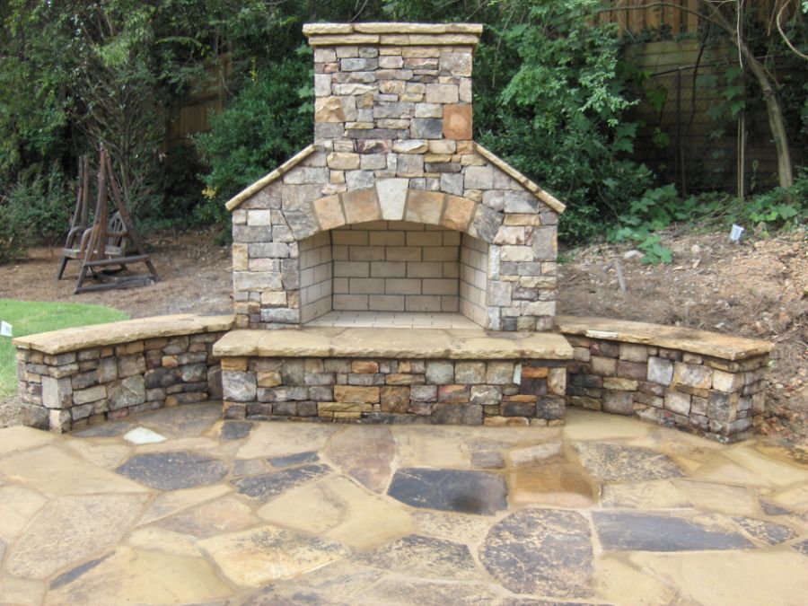 A stone fireplace is sitting on top of a stone patio