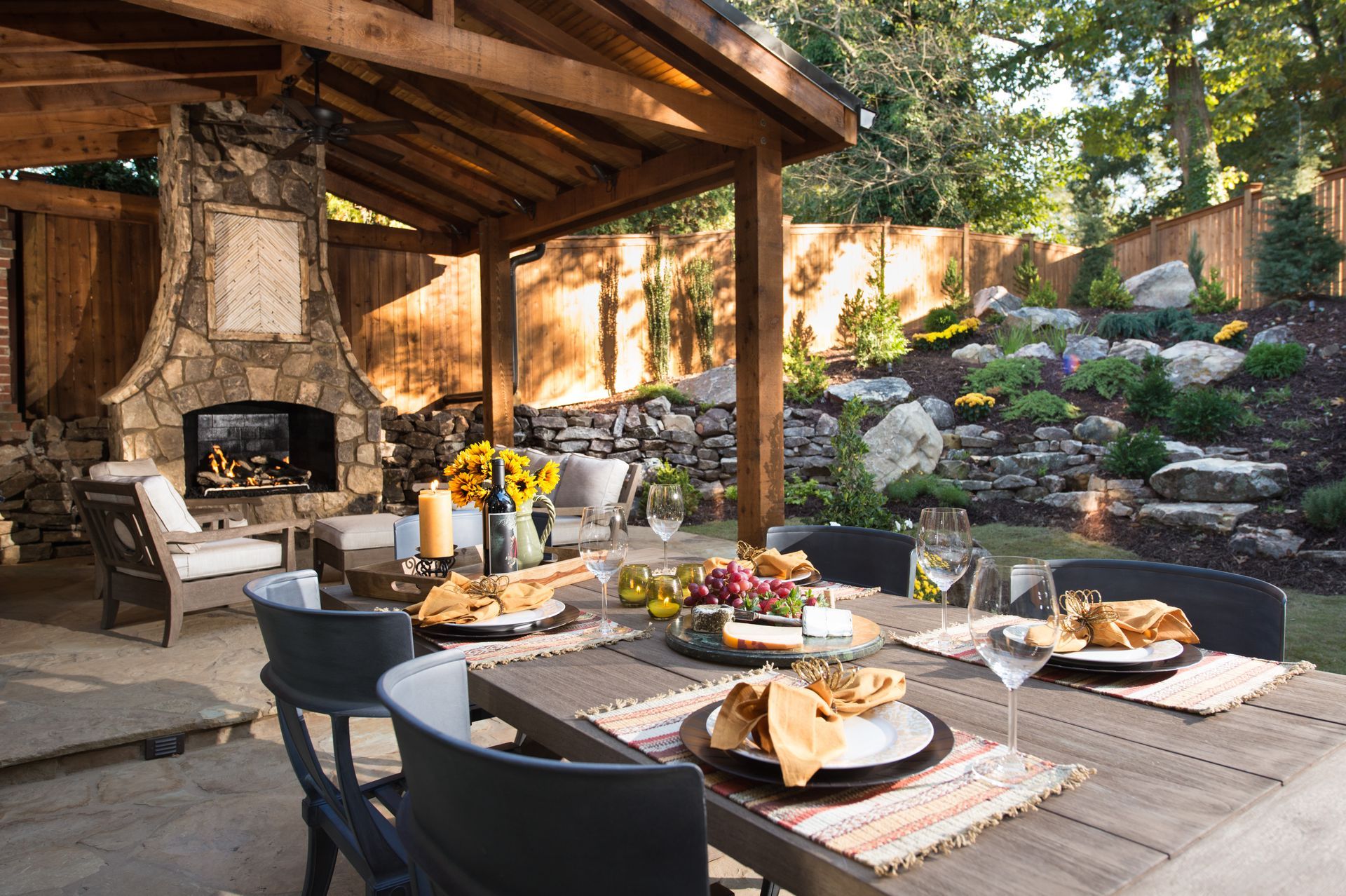 A patio with a table and chairs and a fireplace