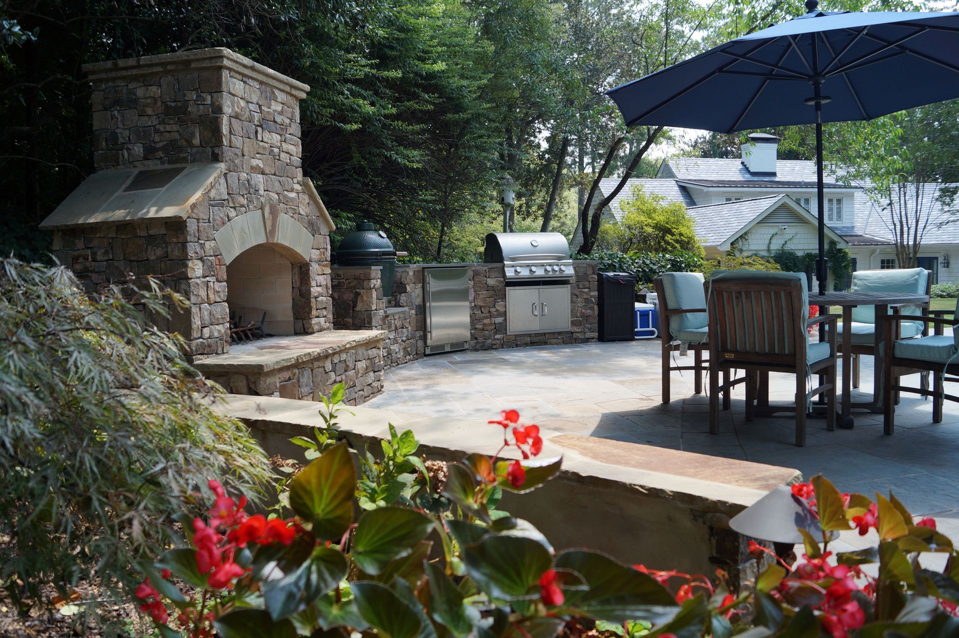 A patio with a fireplace , grill and umbrellas