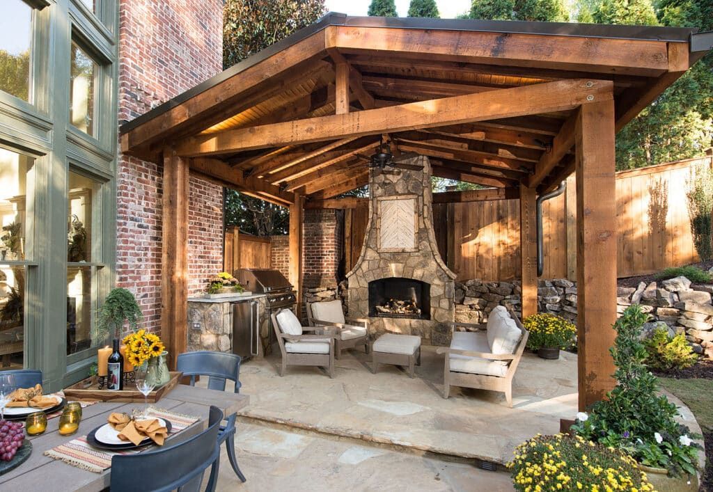 A patio with a table and chairs and a fireplace