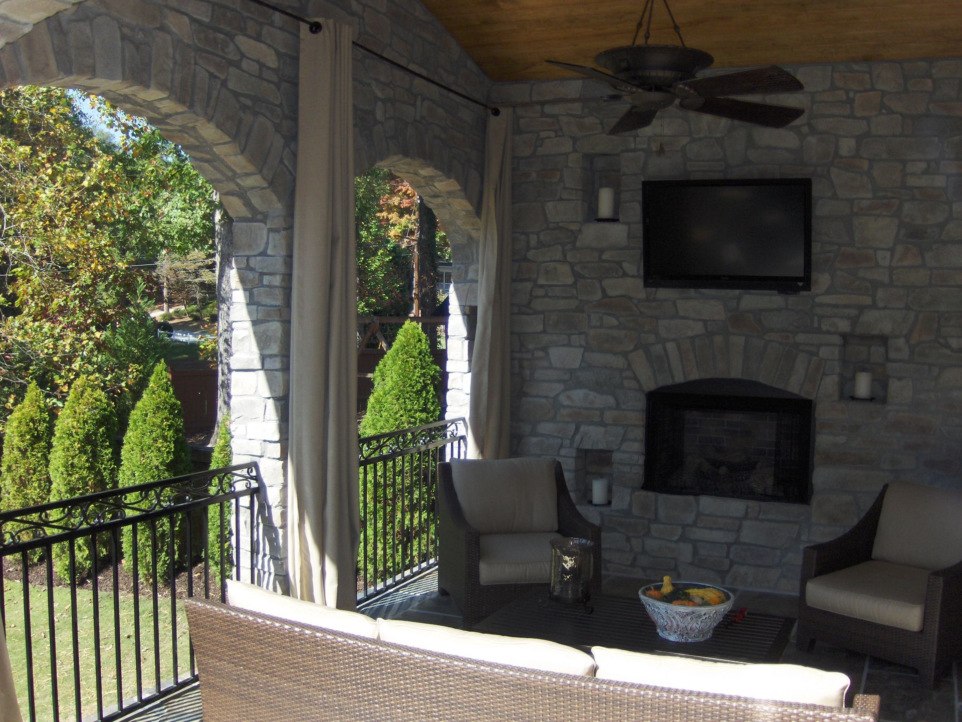 A living room with a fireplace and a ceiling fan