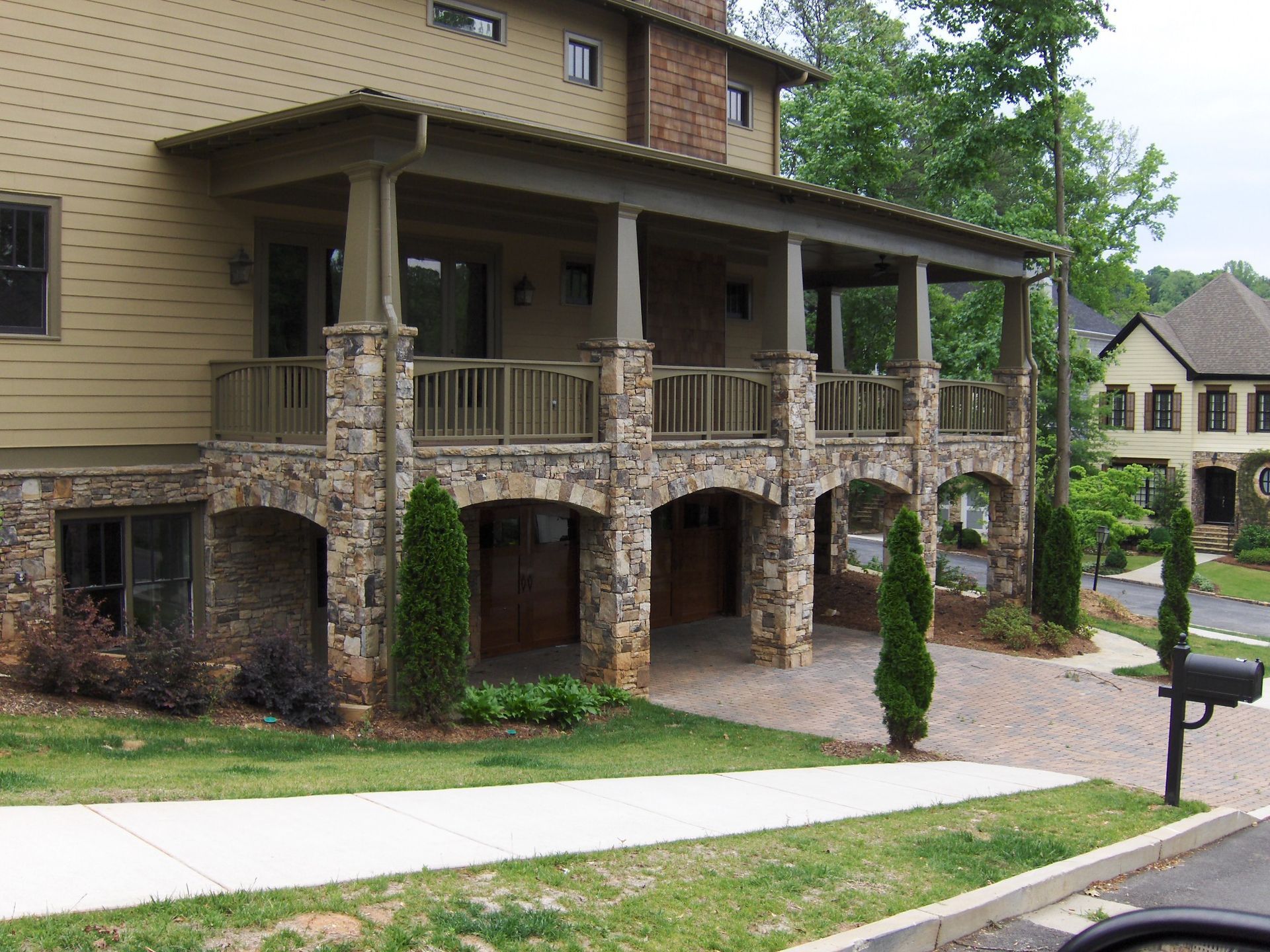 A house with a large porch and a mailbox in front of it