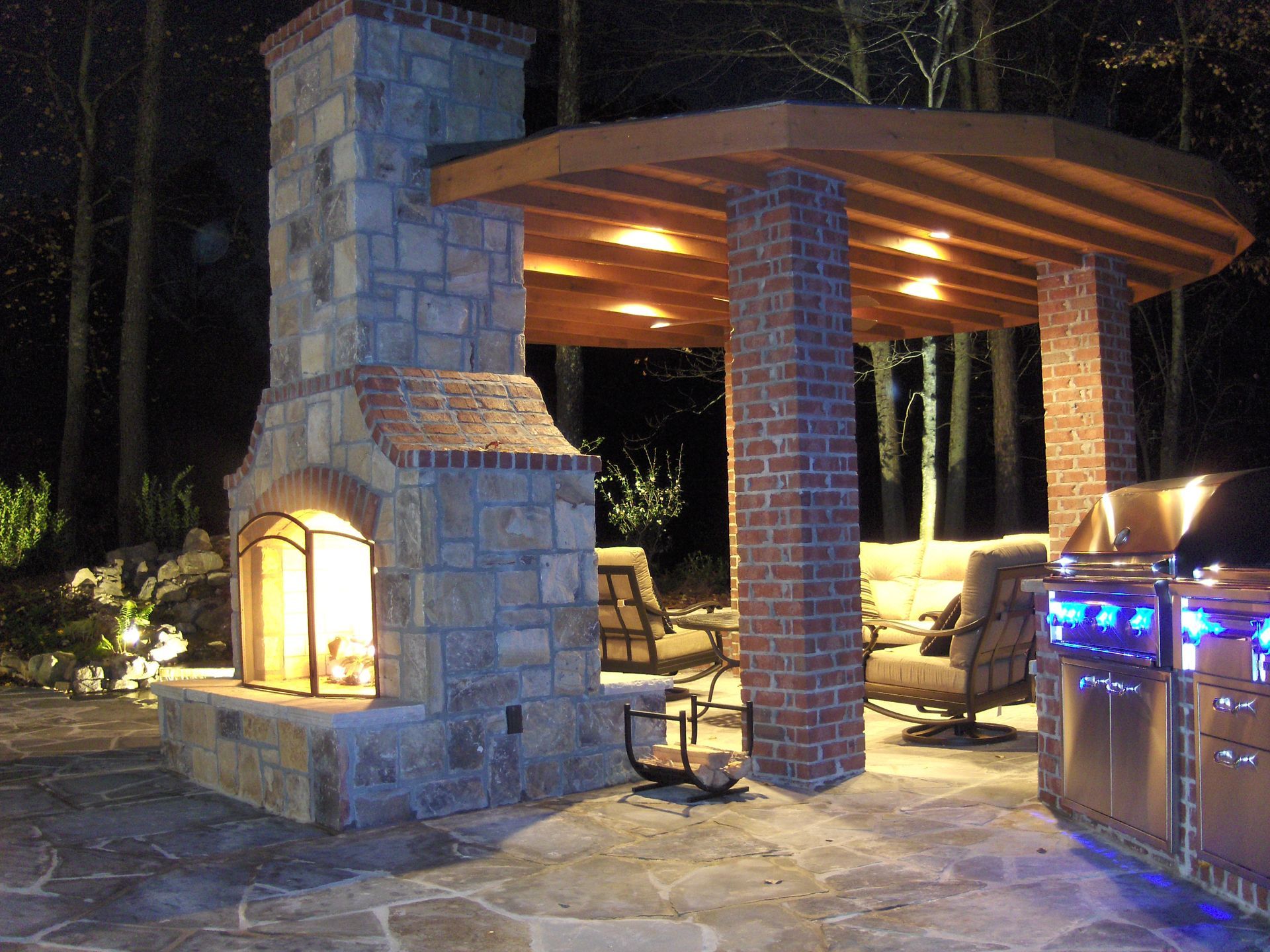 A large stone fireplace is lit up at night