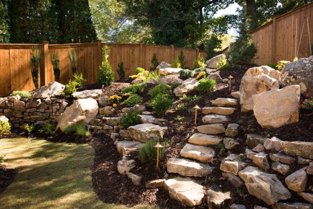 A rock garden with a wooden fence in the background