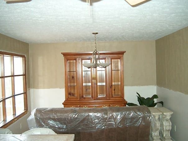 A living room with a hutch and a ceiling fan