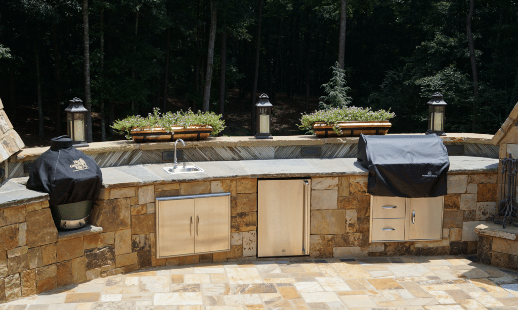 An outdoor kitchen with a grill and a sink