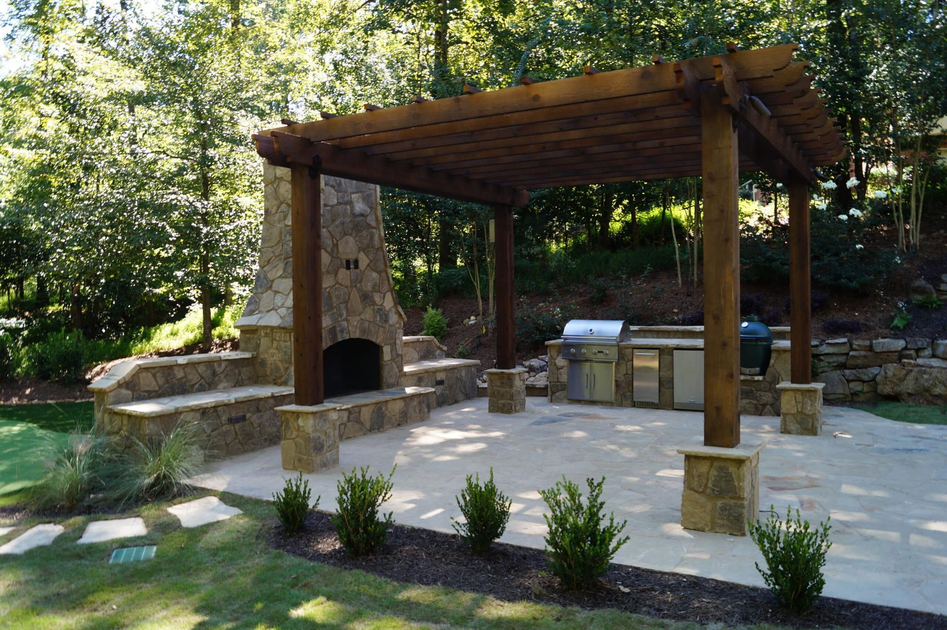 A patio with a wooden pergola and a fireplace