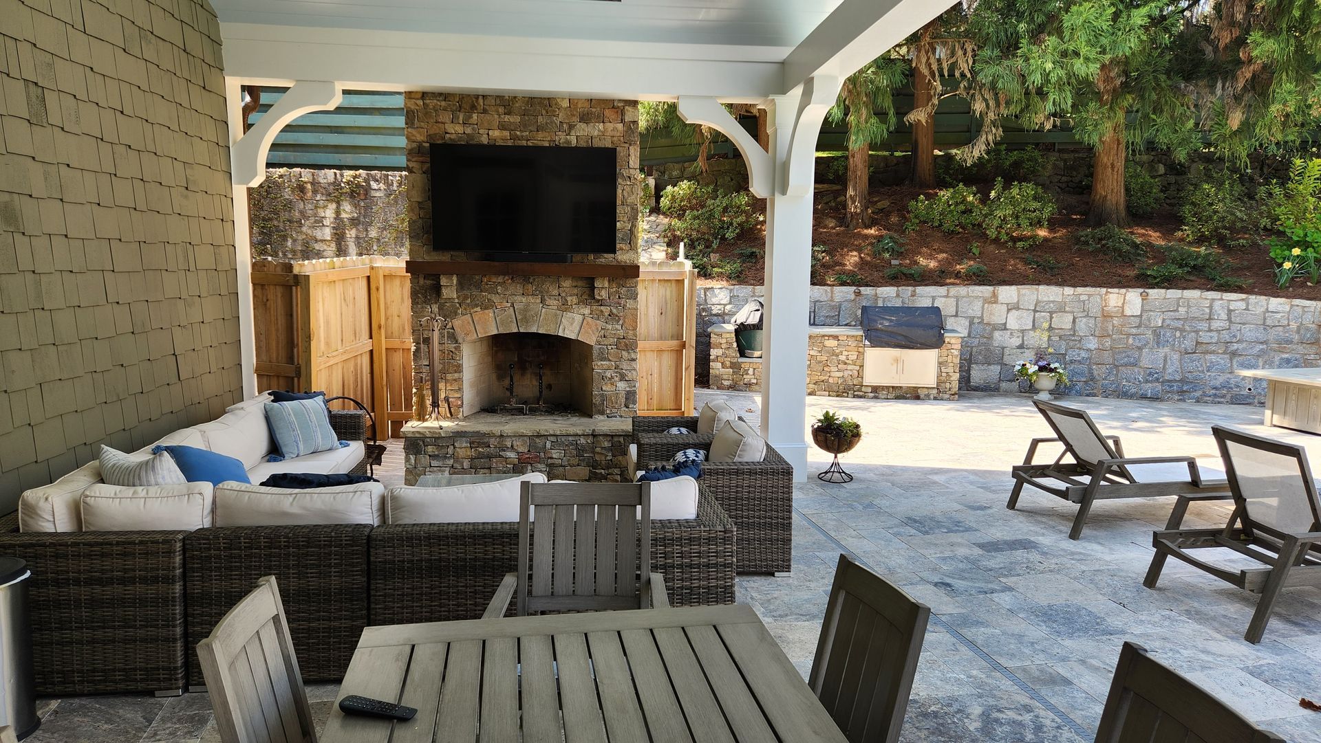 A patio with a table and chairs and a fireplace.