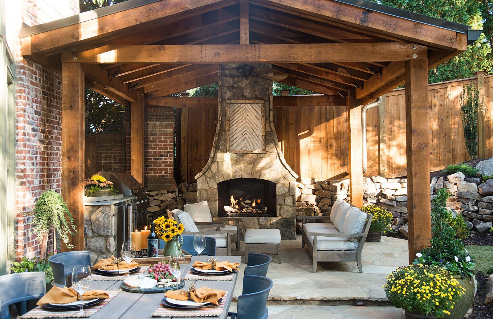 A patio with a table and chairs and a fireplace