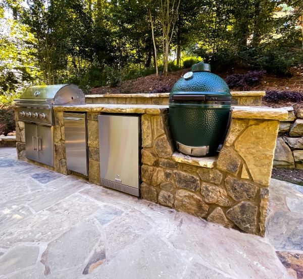 A stainless steel grill is sitting on top of a stone counter.