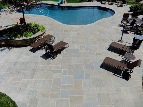 An aerial view of a patio with chairs and a pool and pa bluestone 