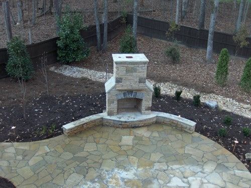 An aerial view of a patio with a fireplace in the middle of it.