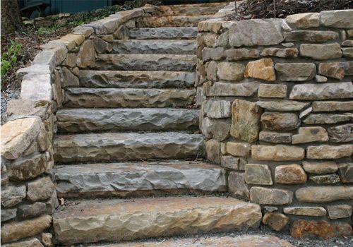 A set of stone stairs leading up to a stone wall