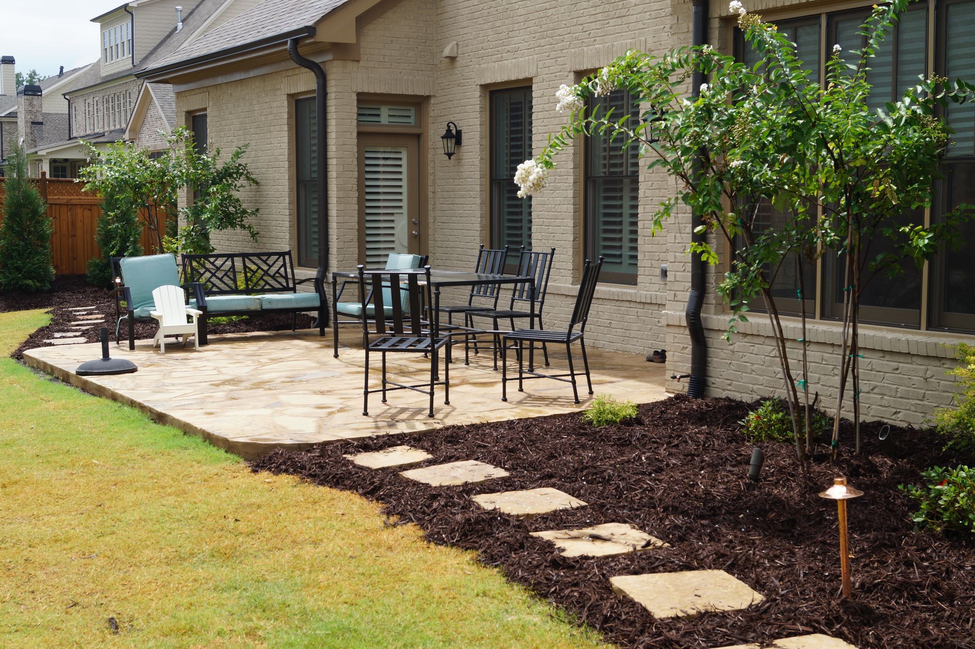 A patio with a table and chairs in front of a house