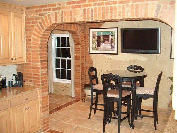 A kitchen with a table and chairs and a flat screen tv