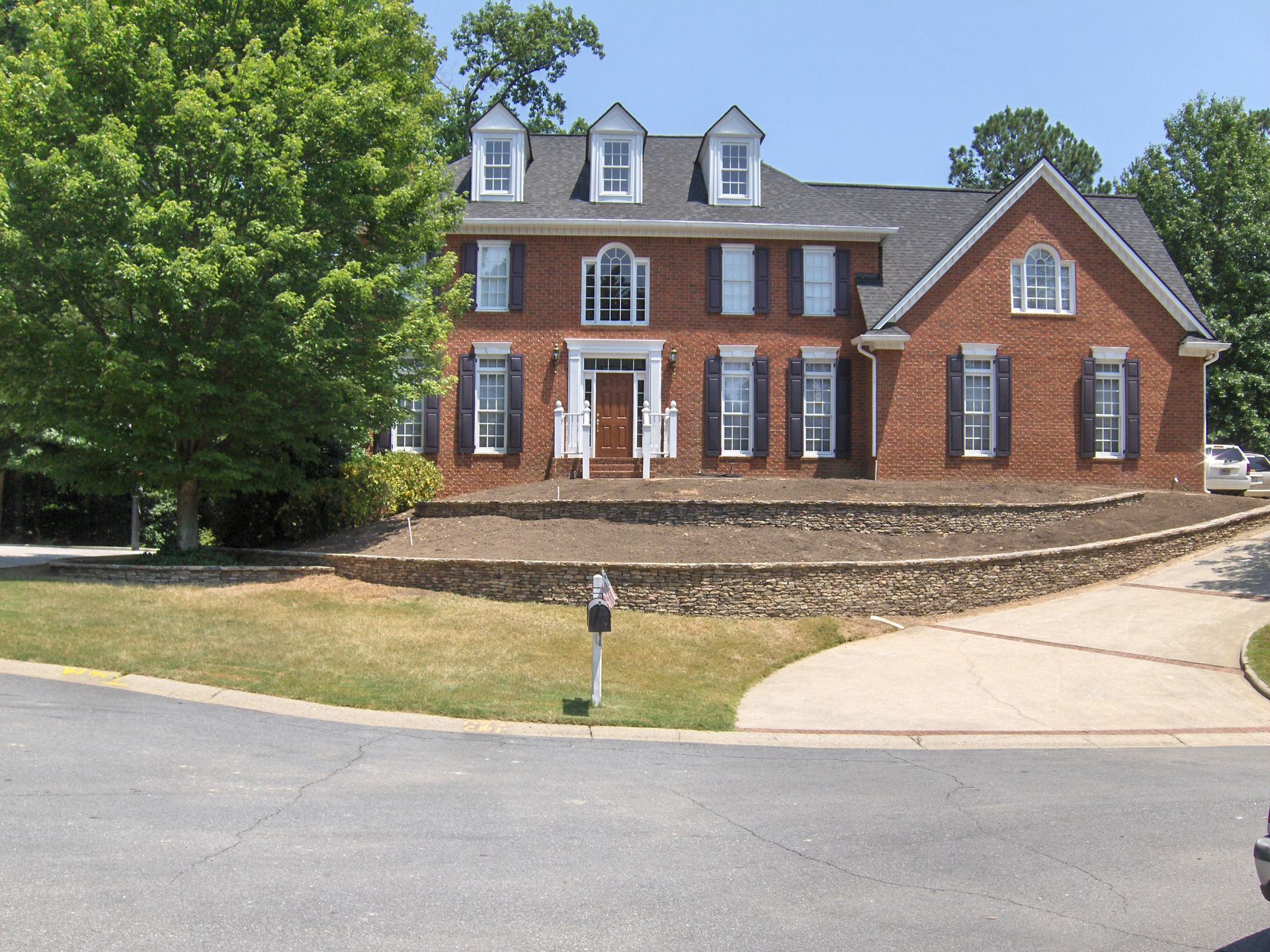 A large brick house with white shutters on the windows