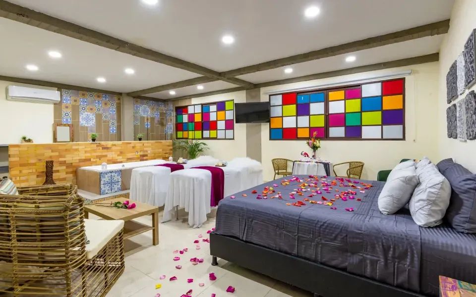 Habitación decorada con pétalos y velas en NQ Hotel Orinoquía Villavicencio, plan romántico en pareja con alojamiento exclusivo.”