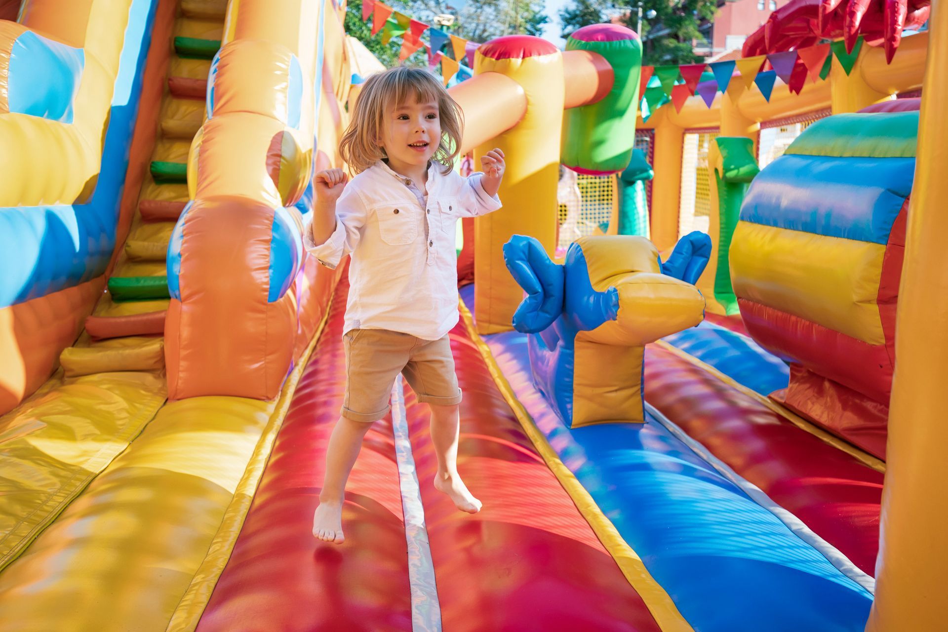 Little kid having fun in inflatable castle playground.
