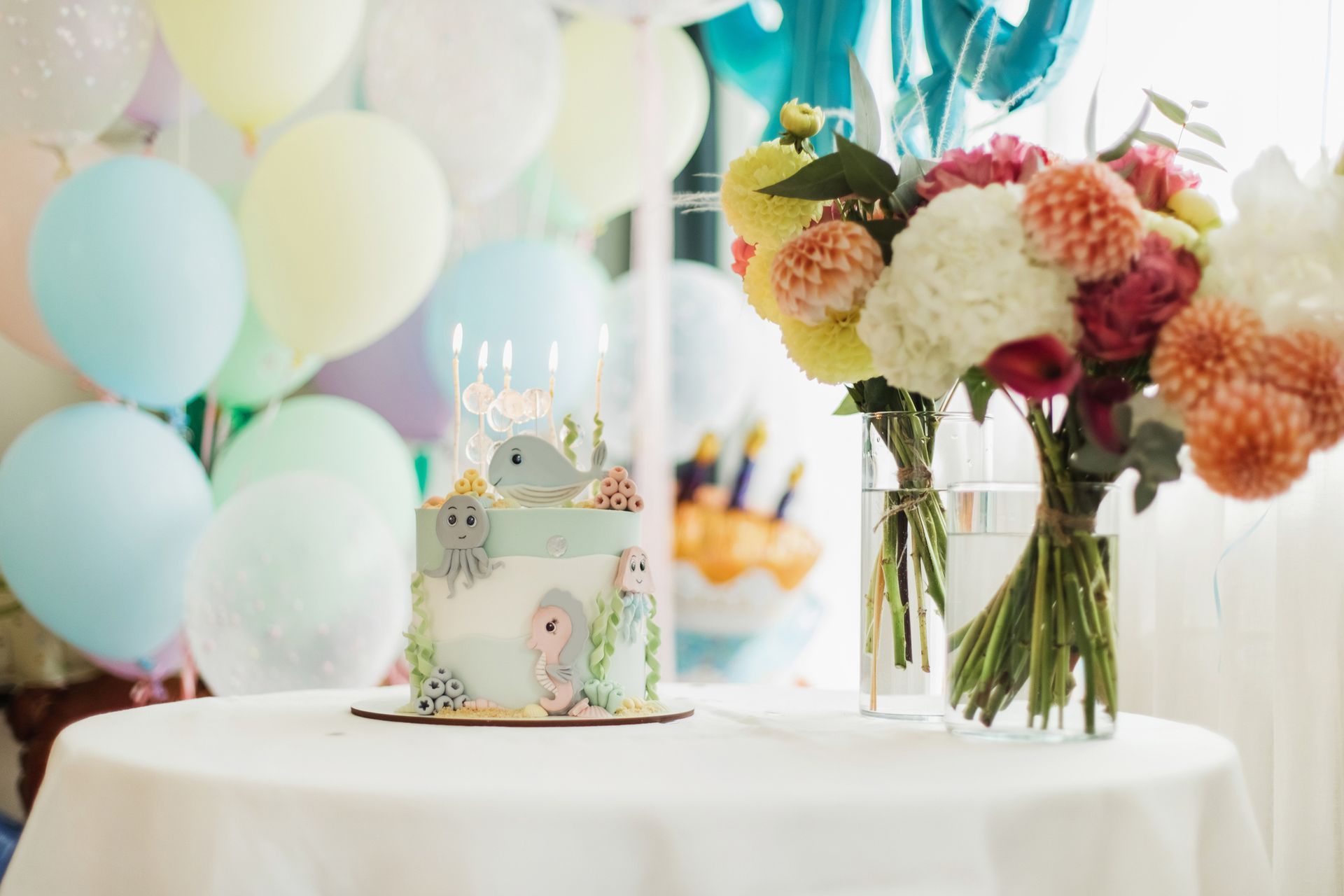 A birthday cake is sitting on a table next to a vase of flowers.